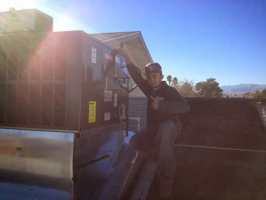 HVAC technician performing Boiler Repair on a rooftop unit in Odessa